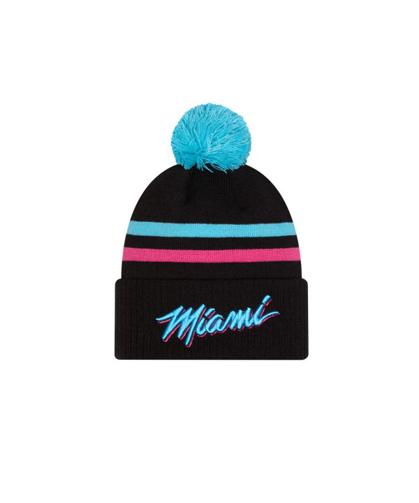 The New Era Miami HEAT Original Vice Nights Knit is a black acrylic beanie with a blue pom-pom, turquoise and pink stripes, and “Miami” embroidered on the front cuff. One size fits most; spot clean for best care.