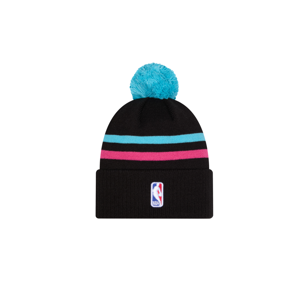 The New Era Miami HEAT Original Vice Nights Knit is a black acrylic beanie with pink and teal stripes, a teal pom-pom, and an NBA logo patch on the front cuff. One size fits most; spot clean. Shown on a white background.