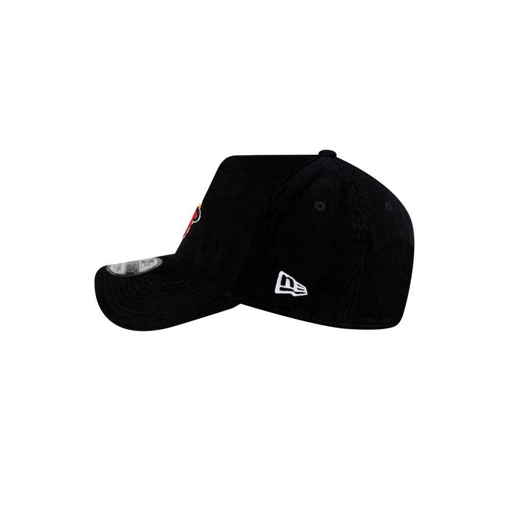 Side profile of a black corduroy Court Culture x New Era Corduroy Logo Dad Cap featuring an A-frame shape, a white logo on the side, and a sticker on the curved brim.