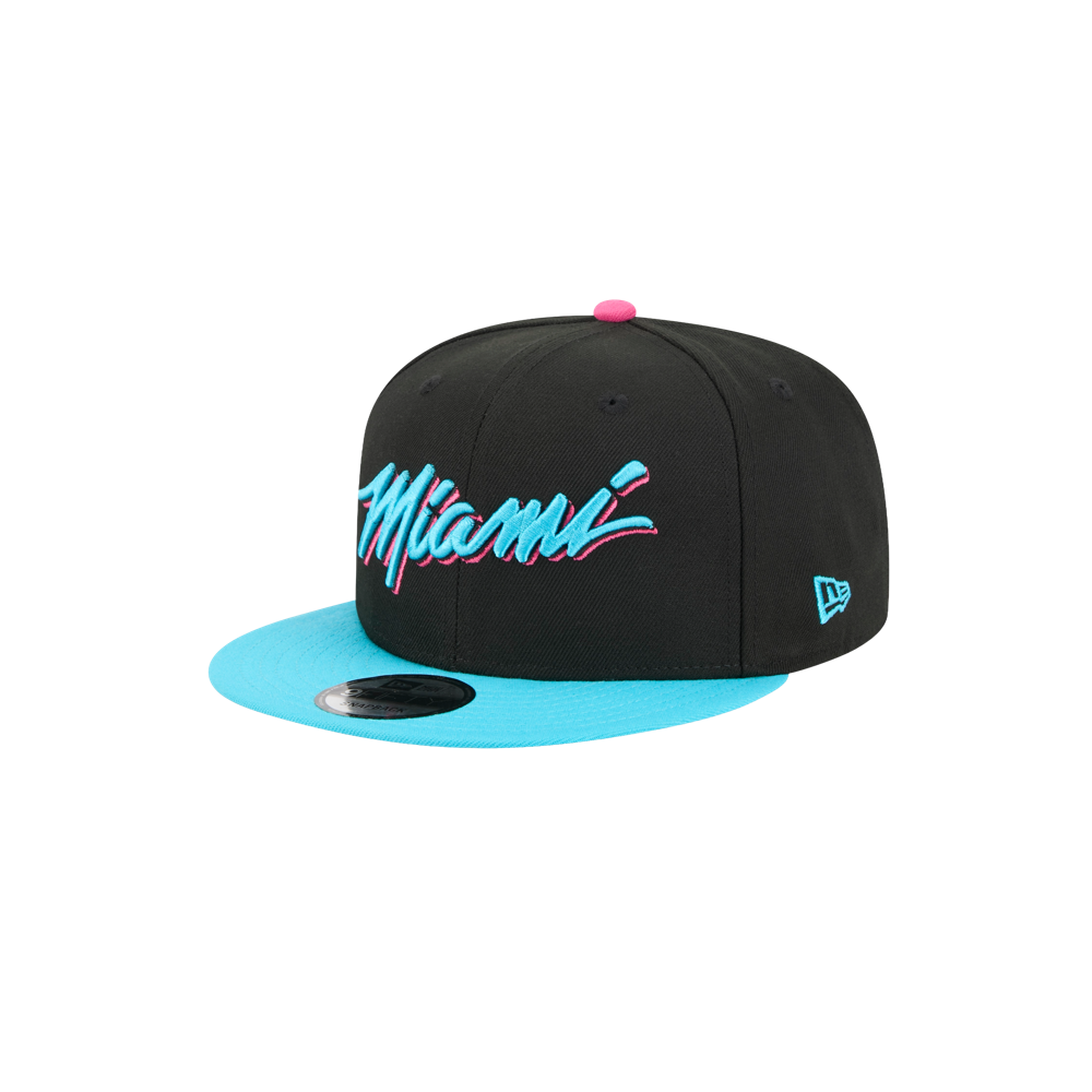 The New Era Miami HEAT Original Vice Nights Snapback features a black crown, blue flat brim, pink button, and teal/pink 