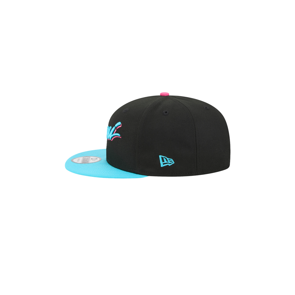 The New Era Miami HEAT Original Vice Nights Snapback is a black polyester hat with a bright blue flat brim, pink top button, and blue embroidered New Era logo. One size fits most. Spot clean only. Shown on a white background.