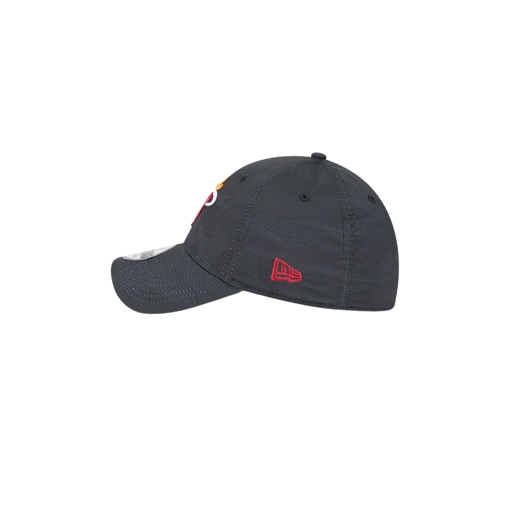 The New Era Miami HEAT Tonal Camo Flex Fit Hat is a dark gray polyester-spandex cap, seen from the side with visible stitching and a small red logo above the back opening. Spot clean for best care. Shown on a plain white background.