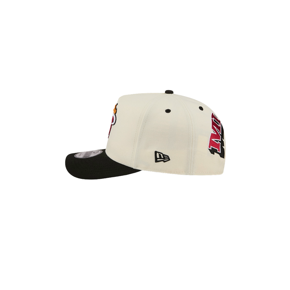 The New Era Miami HEAT Logo Wordmark Snapback by New Era is a white and black polyester baseball cap featuring Miami Heat logos on the front and side. Designed as one size fits most, it is displayed from the side against a plain white background. For best results, spot clean only.