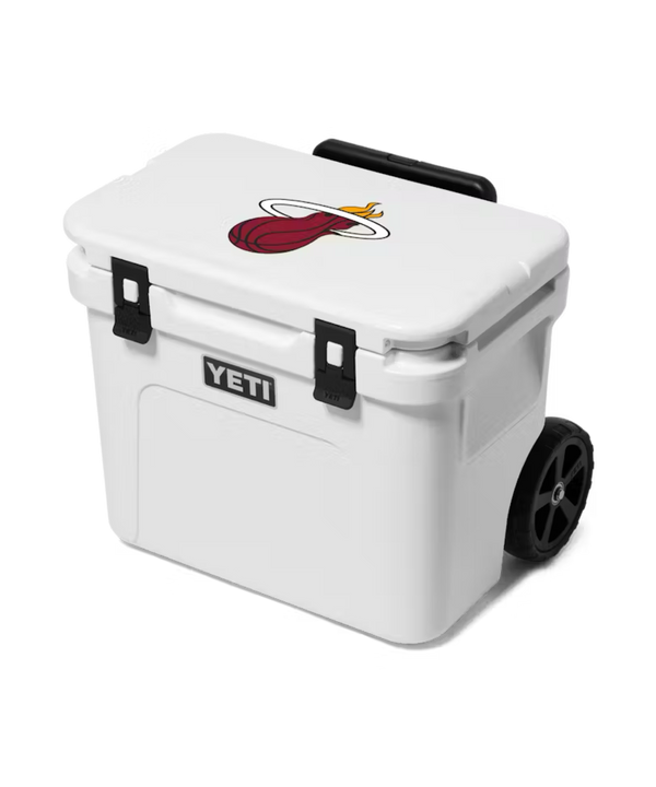 The Yeti Miami HEAT Roadie® 32 Cooler is a durable, wheeled cooler with black latches, wheels, and a Miami Heat logo on the lid. Compact and trunk-friendly, it's perfect for easy transport to games or gatherings.