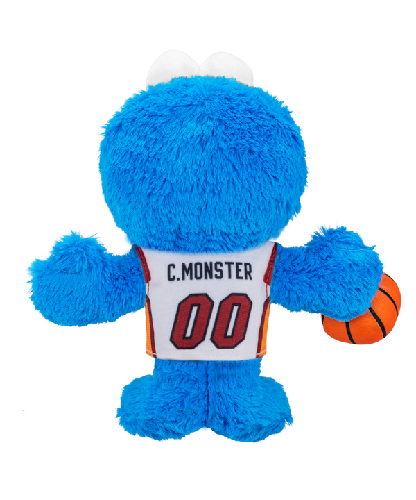 The Miami HEAT Cookie Monster Association Plushie by Bleacher Creatures is a blue plush toy featuring large eyes, a big black mouth, and a friendly expression. Dressed in a white Miami HEAT basketball jersey with “HEAT 00” and holding an orange basketball, this plush is inspired by Cookie Monster from Sesame Street.