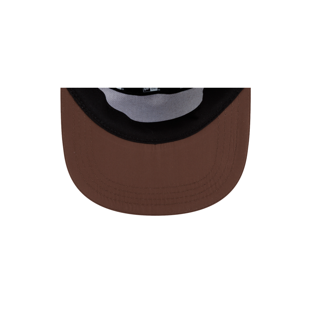 The underside of a brown polyester Court Culture x New Era Mocha 5-Panel Hat brim showing a black interior sweatband and internal seam tape.