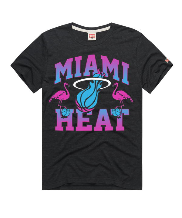 The Homage Miami HEAT Original Vice Nights Flamingo Tee by Homage features large pink and blue MIAMI HEAT text, a blue flaming basketball logo, and two pink flamingos holding basketballs on a soft black blend.