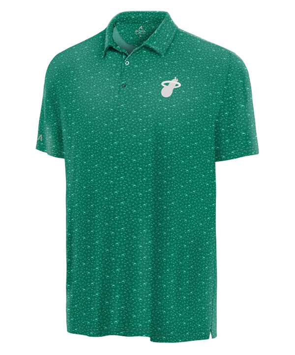 The Antigua Miami HEAT St. Patrick’s Day Polo by Antigua is a green, short-sleeve polo with a white Miami Heat logo on the left chest, subtle dotted pattern, standard fit, three-button collar, and is machine wash cold for easy care.