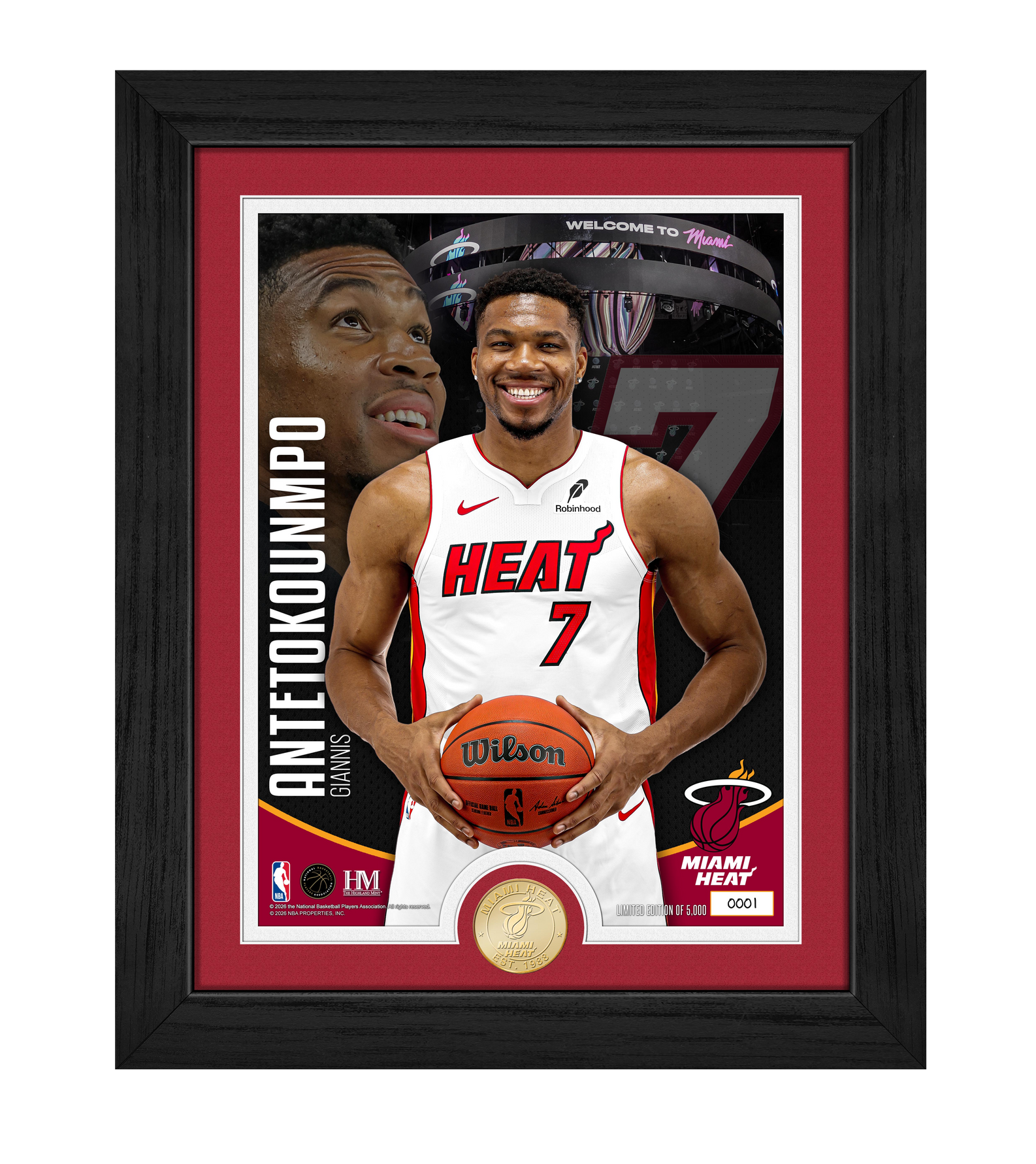The Highland Mint Giannis Antetokounmpo Miami HEAT Bronze Coin Photo Mint features a framed photo of the basketball star wearing a Miami Heat jersey with 'Antetokounmpo' and number 7, holding a basketball. The background showcases his face, the official Miami Heat logo, and includes a gold-toned collectible coin at the bottom. This limited edition NBA memorabilia is an ideal choice for fans seeking an exclusive Giannis Antetokounmpo Miami Heat collectible or a unique addition to their collection.