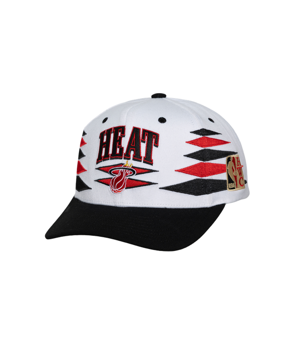 The Mitchell & Ness Miami HEAT Diamond Cut Snapback features white and black polyester, red and black geometric patterns, HEAT text, the team logo on front, NBA patch on the side, and a black brim. One size fits most; spot clean only.