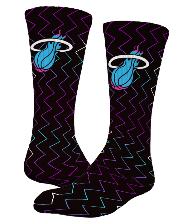 The ISlide Miami HEAT Original Vice Nights Logo Socks feature zigzag patterns in purple, blue, and pink, a blue and white flaming basketball logo, plus moisture-wicking comfort and arch support for all-day wear.