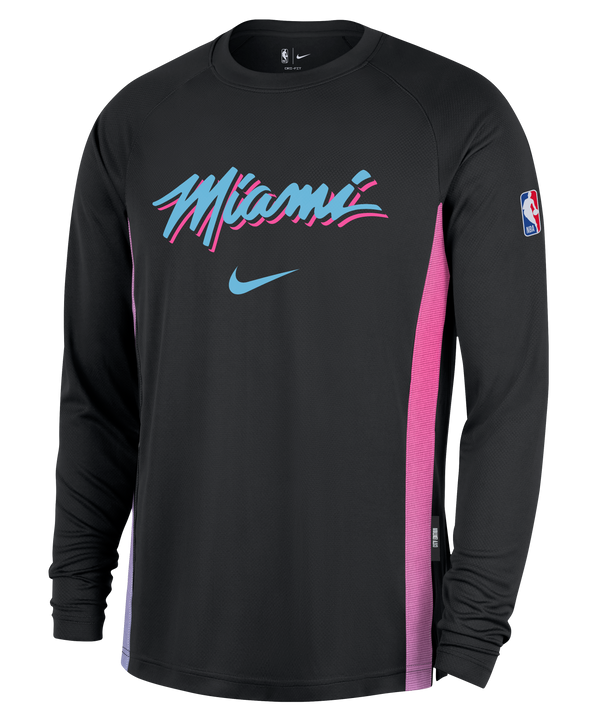 The Nike Miami HEAT Original Vice Nights Shooting Shirt is a long-sleeve black shirt with “Miami” in pink, blue, and white script, purple/pink side panels, NBA logo on the sleeve, standard fit, and durable polyester. Wash with like colors.
