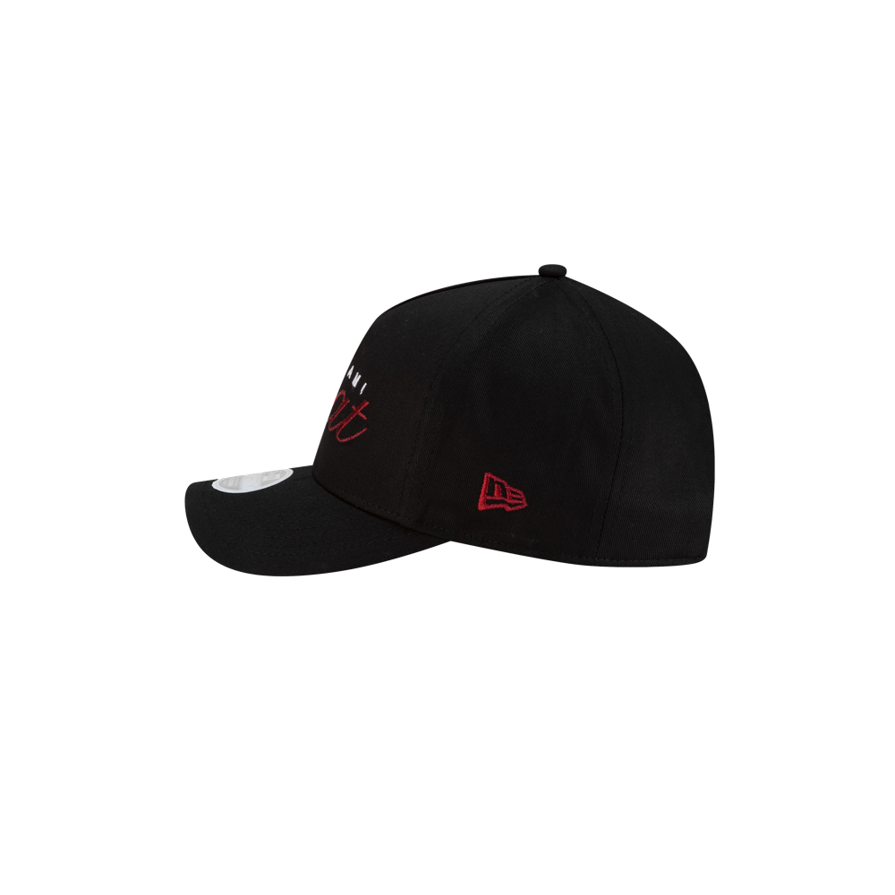 A side view of the New Era Miami HEAT Metallic Women's Hat shows a black cap with a curved brim, red embroidered details, and a white tag on the visor. The background is plain white. Brand: New Era.