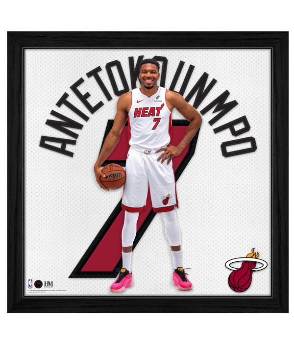 A basketball player in a Miami Heat uniform stands holding a ball, with Antetokounmpo and the number 7 behind him, and the Miami Heat logo in the corner. The Highland Mint Giannis Antetokounmpo Miami HEAT Impact Jersey Frame is an officially licensed, framed NBA art piece that captures an iconic moment for any fan.