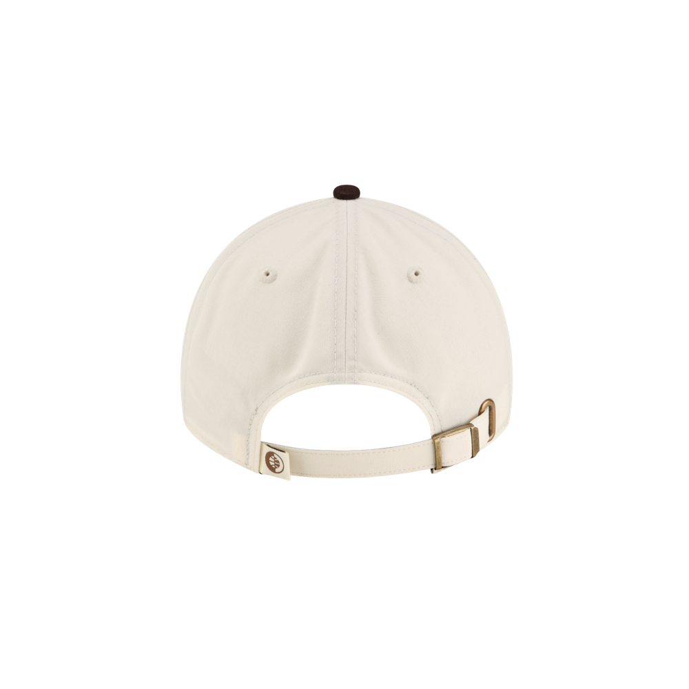 Back view of the cream-colored Court Culture x New Era Café y Leche Dad Cap, featuring a dark brown button on top and an adjustable brass strap closure.