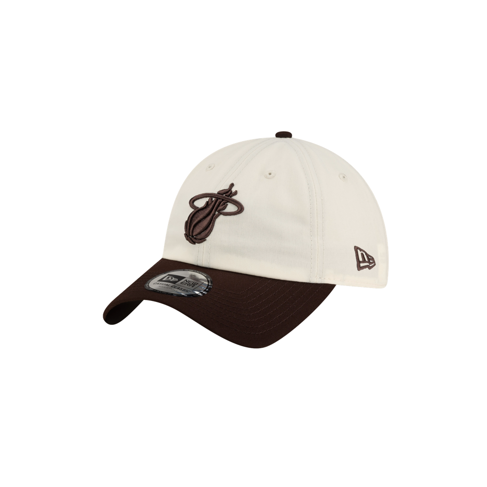Court Culture x New Era Café y Leche Dad Cap featuring a cream-colored polyester hat with a dark brown brim and a brown Miami Heat logo on the front.