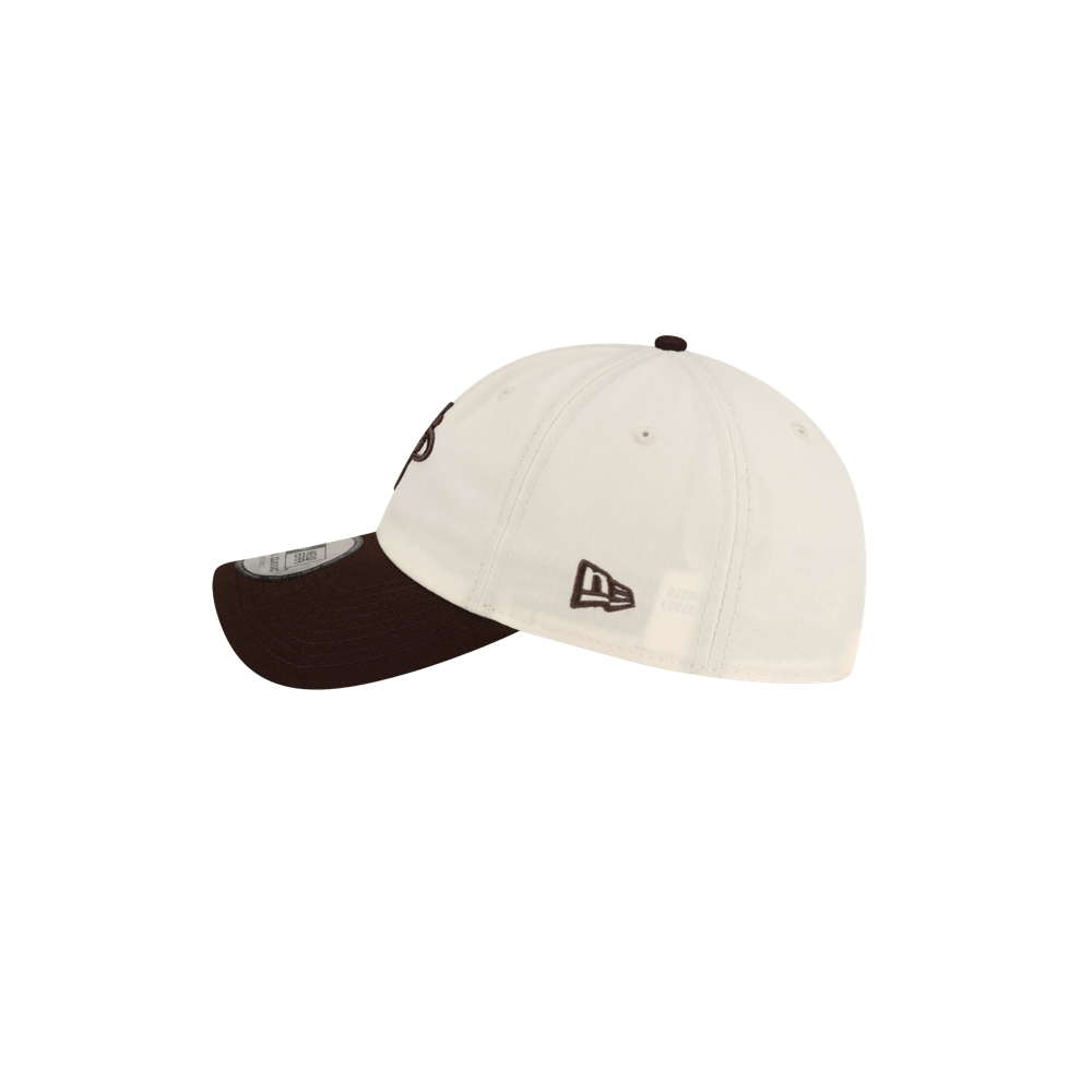 Court Culture x New Era Café y Leche dad cap in off-white polyester with a dark brown brim and dark brown embroidered logos on the side and front.