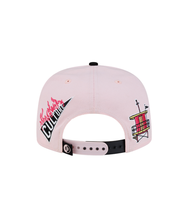 The Court Culture Original Vice Patch Snapback by Court Culture features a light pink and black polyester construction with a slim crown and various embroidered designs, such as palm trees, “EST 1988,” and a stylized logo on the front. Its squared visor is black with pink text on the side.