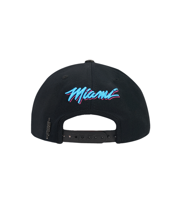 The Pro Standard Miami HEAT Original Vice Nights Snapback by Pro Standard is a black wool-acrylic hat with a blue, pink, and white Heat logo on the front, one size fits most, leather button detail. Shown on a plain white background.