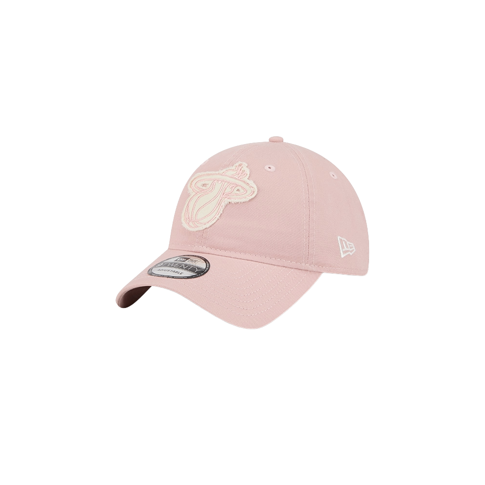 The New Era Miami HEAT Pink Stamp Dad Hat is a light pink cotton cap with the Miami Heat logo embroidered in white on the front, a curved brim, and New Era branding on the side. One size fits most; spot clean only. Set against a plain white background.