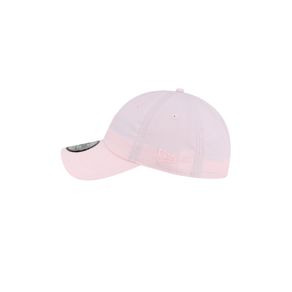 Side view of a light pink Court Culture x New Era Breast Cancer Awareness Dad Hat featuring an embroidered logo on the left panel and a sticker on the curved brim.