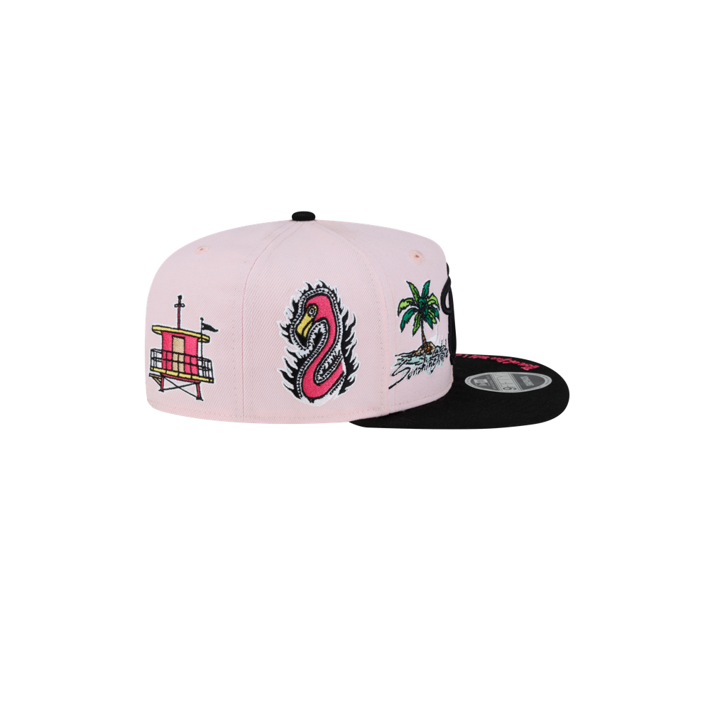 The Court Culture Original Vice Patch Snapback by Court Culture is a light pink polyester hat with a slim crown, decorated with dragon, palm tree, and building patches on the side, and finished with a black squared visor.