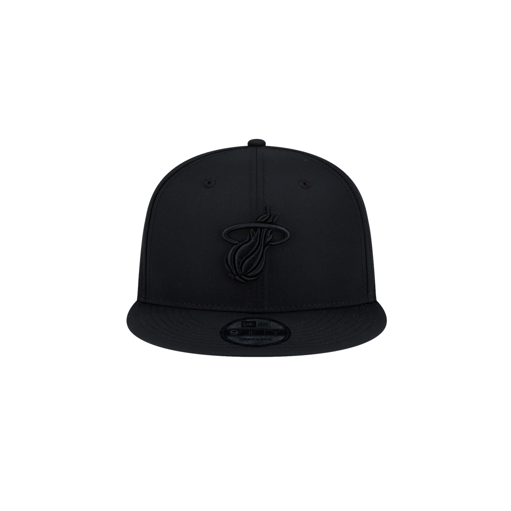 Court Culture x New Era Blackout Snapback hat in black, featuring a matching black Miami Heat logo on the front and a circular sticker on the flat brim.