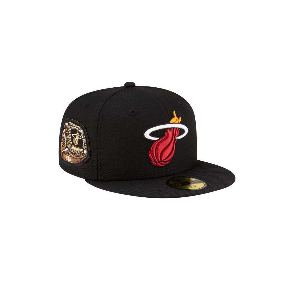 The New Era Miami HEAT 06' Ring Fitted Hat is a black wool cap with the Heat logo on the front, a gold championship patch on the side, and a gold sticker on the flat brim. Fitted structure; spot clean for best results.