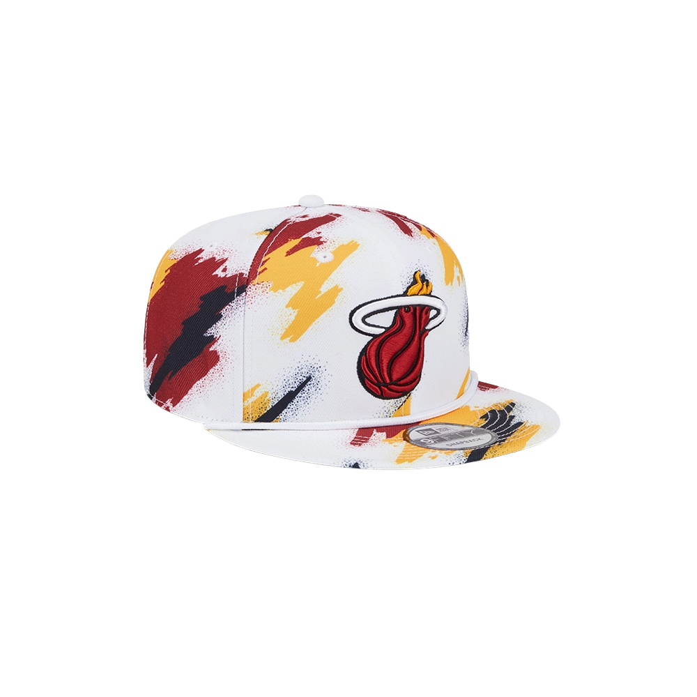 The New Era Miami HEAT Youth Paint Snapback features a white polyester build with red, yellow, and black paint splatter, plus an embroidered Miami Heat logo on the front. One size fits most; spot clean only.