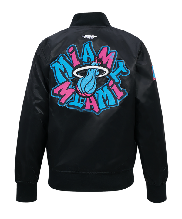 The Pro Standard Miami HEAT Original Vice Nights Youth Satin Jacket is a black polyester varsity jacket with blue and pink graffiti-style patches, including the team logo, MIAMI HEAT, and HEAT. It features a button-up front, ribbed cuffs, and collar.