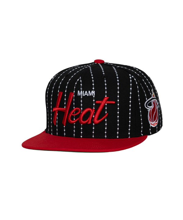 The Mitchell & Ness Miami HEAT Pinstripe Snapback is a black polyester cap with white pinstripes, red flat brim, Heat embroidery in red and white, team logo on the side, easy spot clean design, and adjustable fit.