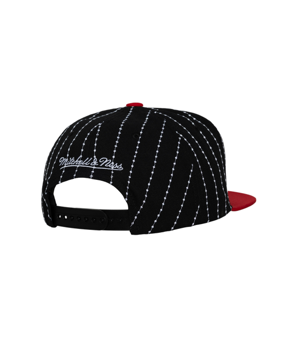 The Mitchell & Ness Miami HEAT Pinstripe Snapback is a black polyester cap with white pinstripes, red flat brim, Heat embroidery in red and white, team logo on the side, easy spot clean design, and adjustable fit.