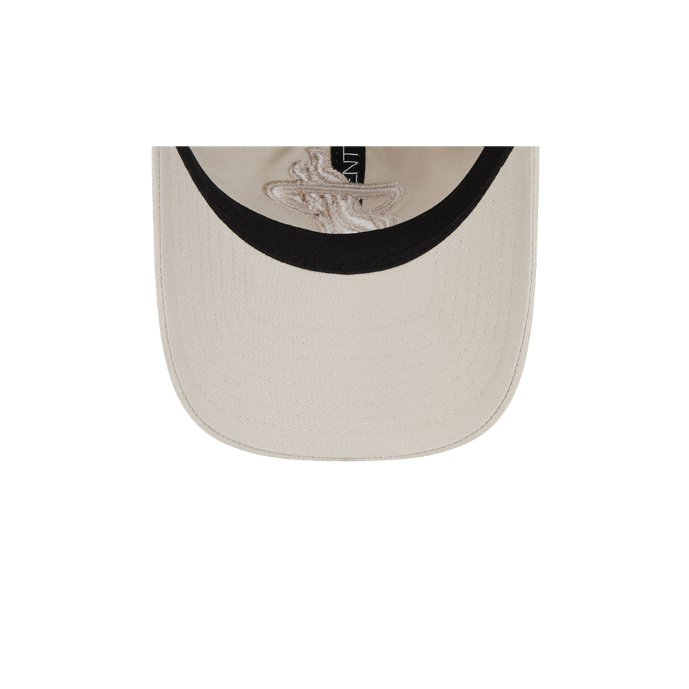 Stone color dad hat with black inner lining and curved brim, adjustable strap at back.