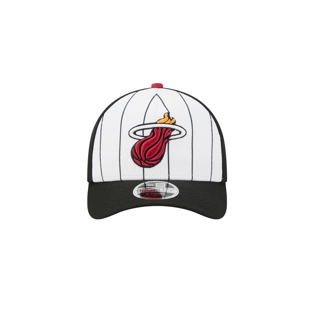 The New Era Miami HEAT 2025 Tipoff Snapback features black pinstripes, a black brim, and the flaming basketball logo, finished with a classic silver New Era sticker on the brim.