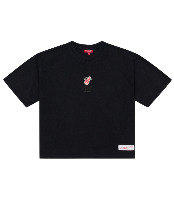 The Mitchell & Ness Miami HEAT Core Logo Women’s Crop Tee is a black, short-sleeve cotton t-shirt with a relaxed fit and cropped length. It features a small Miami Heat logo alongside “Miami” text on the chest and a white rectangular patch near the bottom hem on the left side. This easy-care tee can be simply machine washed and worn.