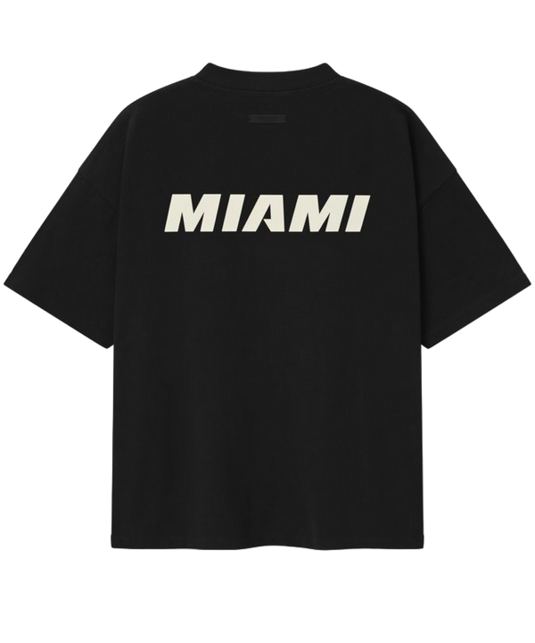 The Essentials Miami HEAT Fear of God Tee by Fear Of God is a black 90s-style oversized cotton jersey featuring the NBA logo and bold white FEAR OF GOD HEAT lettering on the front.