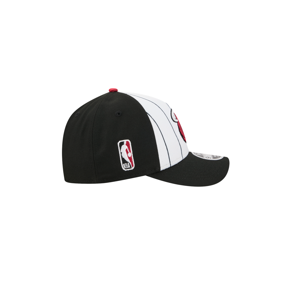 The New Era Miami HEAT 2025 Tipoff Snapback features black and white vertical stripes, a red front logo, an NBA logo patch on the side, and is shown against a plain white background.