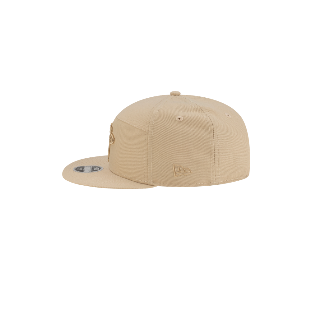The New Era Miami HEAT Tan Youth Snapback, shown upside down at an angle on a white background, features a flat brim and polyester build. One size fits most; spot clean for best care.