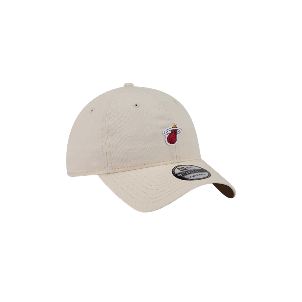 The New Era Miami HEAT Micro Logo Dad Hat is a beige cotton baseball cap with a small Miami Heat flaming basketball logo on the front, a New Era sticker on the curved brim, and an adjustable fit. One size fits most. Plain white background.