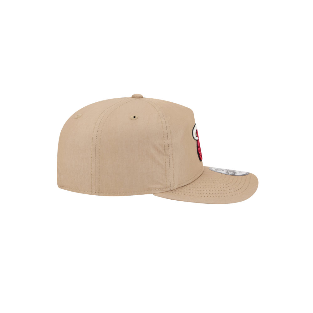 The New Era Miami HEAT Nylon Tan Snapback, shown from the side, features durable cotton nylon with visible stitching and a red and white embroidered front design. Set against a plain white background.