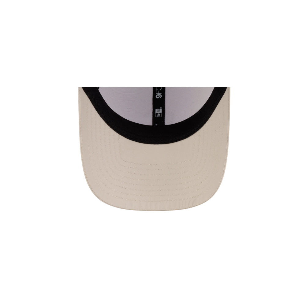 The underside of a light beige Court Culture x New Era Oolite Snapback brim featuring a black interior sweatband and a small brand tag.