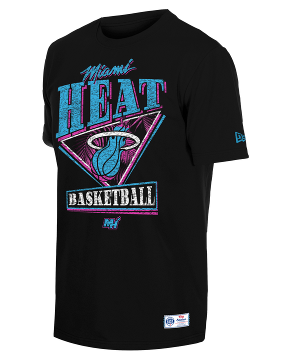 The New Era Miami HEAT Original Vice Nights Graphic Tee features a retro, colorful Miami Heat Basketball graphic with a basketball and flaming hoop logo in teal, pink, and white. Made from soft cotton. Machine wash cold.
