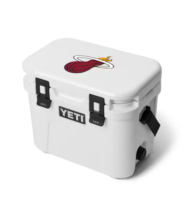The Yeti Miami HEAT Roadie® 15 Cooler is a white insulated cooler with black latches and the Miami Heat logo on the lid, displayed against a plain white background.