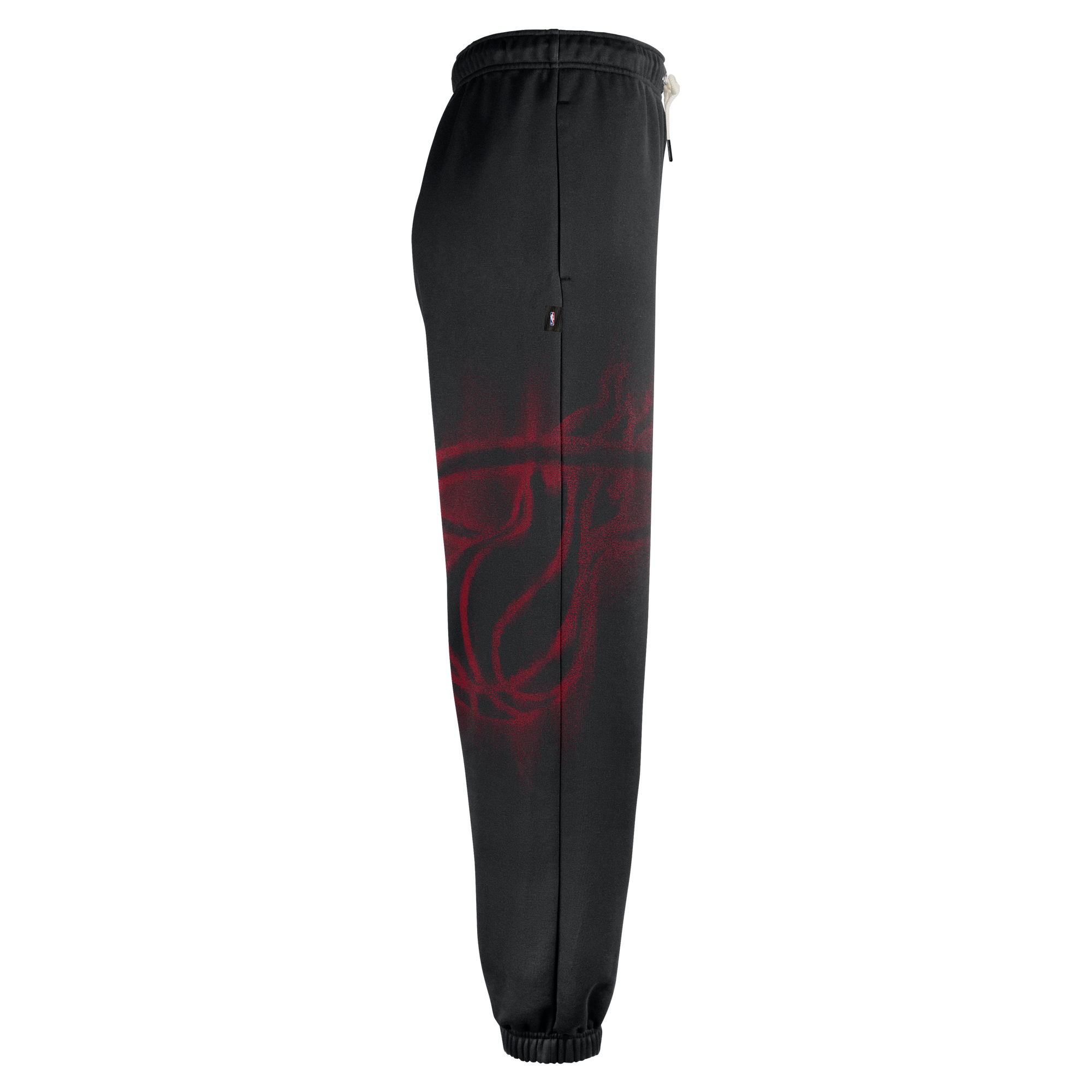 Side view of black Nike Miami HEAT Standard Issue Fleece Pants featuring a large, red, spray-paint style basketball graphic on the leg and a small team logo tag near the waist.